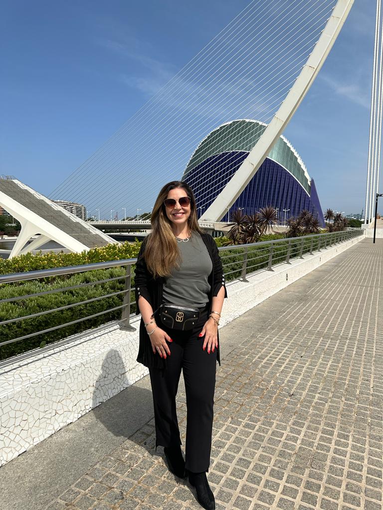 mulher sorrindo em pé na frente de monumento moderno da cidade das artes de valência espanha
