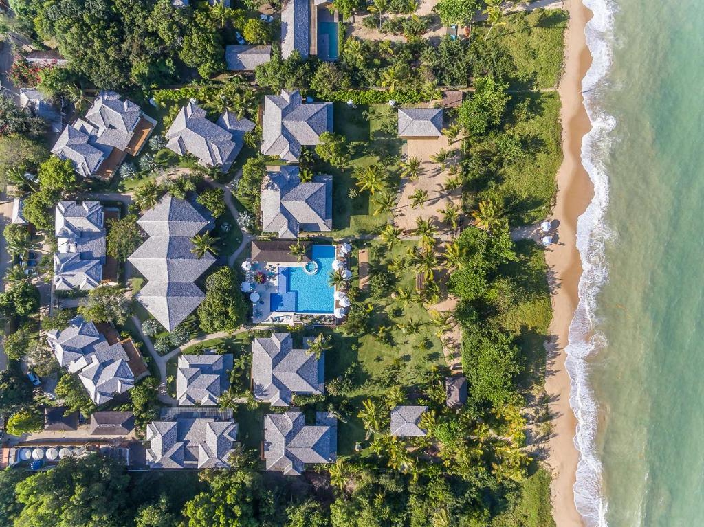 Vista aérea de hotel, piscina e praia em meio a área verde