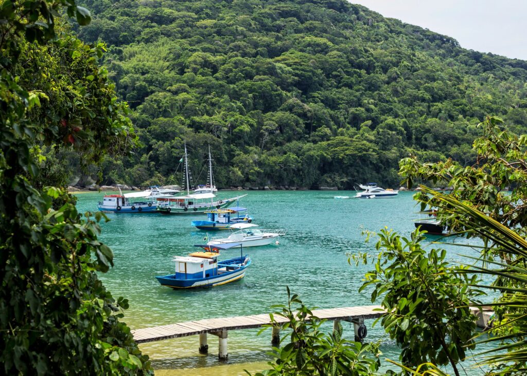 praia com barcos e morro ao fundo