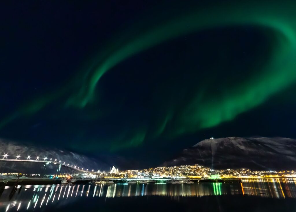 cidade a noite com aurora boreal