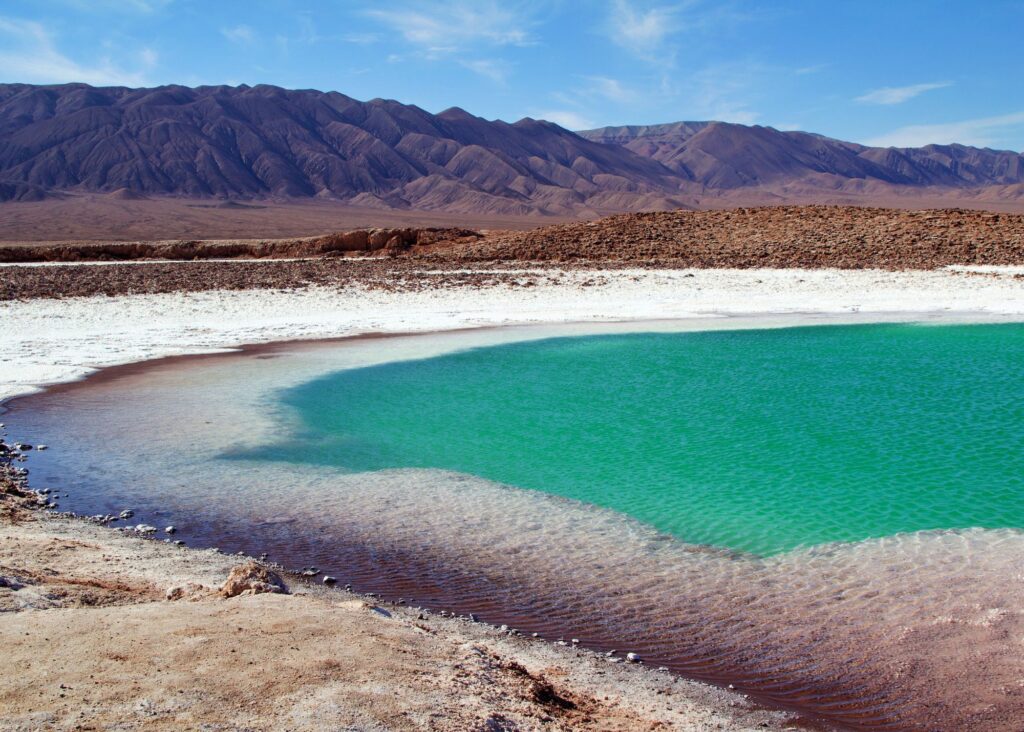 lagoa azulada em meio a deserto e montanhas